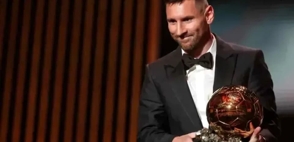 Lionel Messi sosteniendo el Balón de Oro en evento