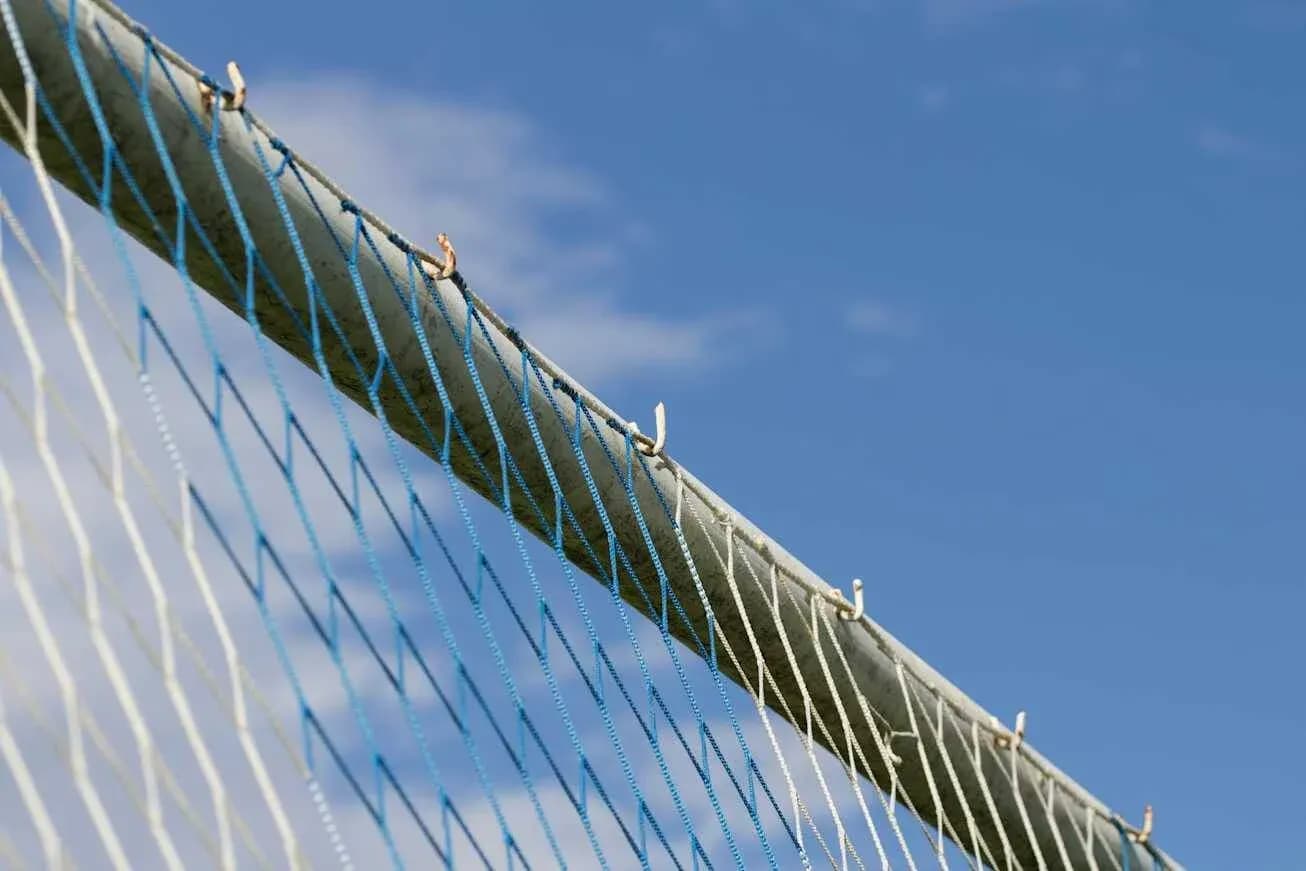 Red de un arco de fútbol contra cielo azul