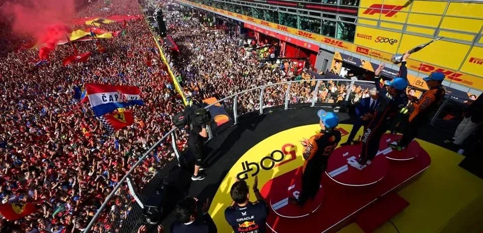 Pilotos celebrando en el podio con multitudes animadas