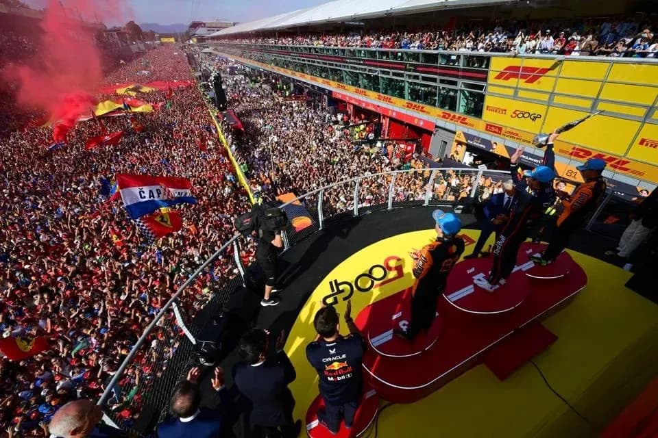 Pilotos celebrando en el podio con multitudes animadas