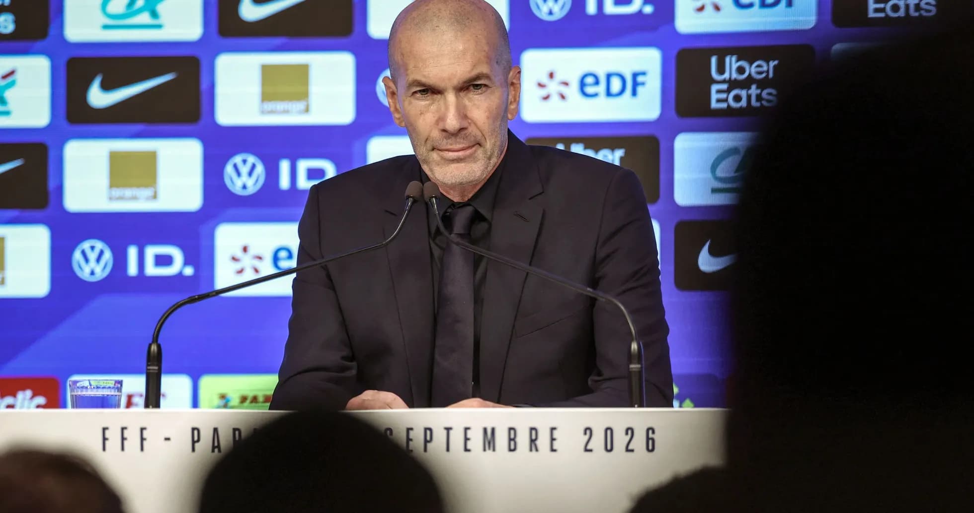 Entrenador en rueda de prensa con fondo de patrocinadores