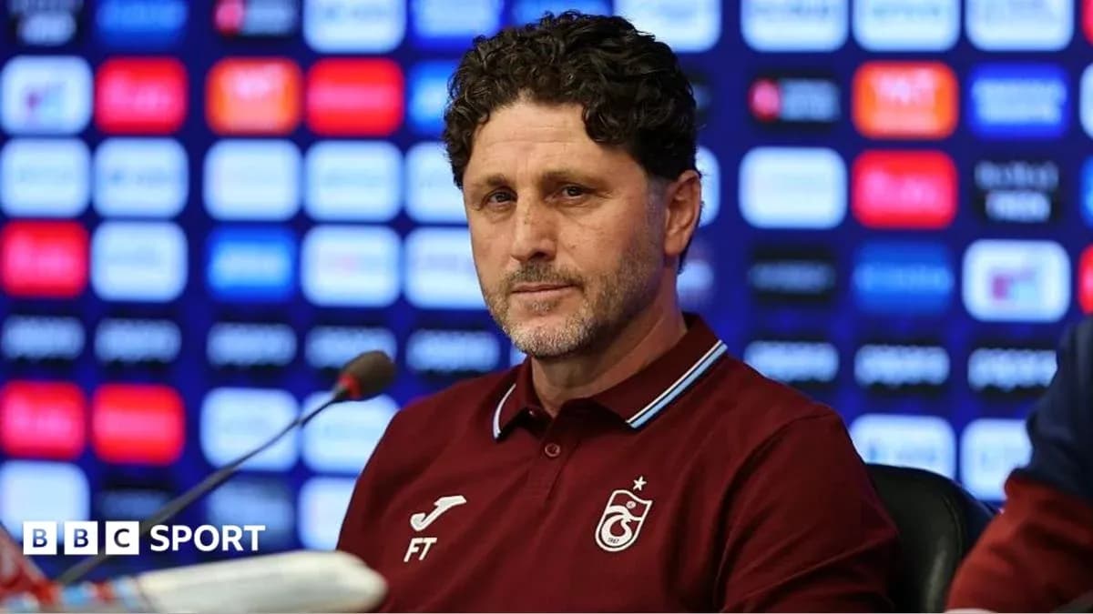 Entrenador en rueda de prensa con fondo de logos