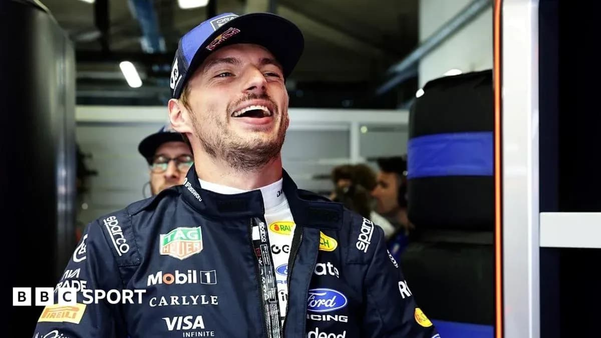 Piloto sonriendo en el garaje de su equipo