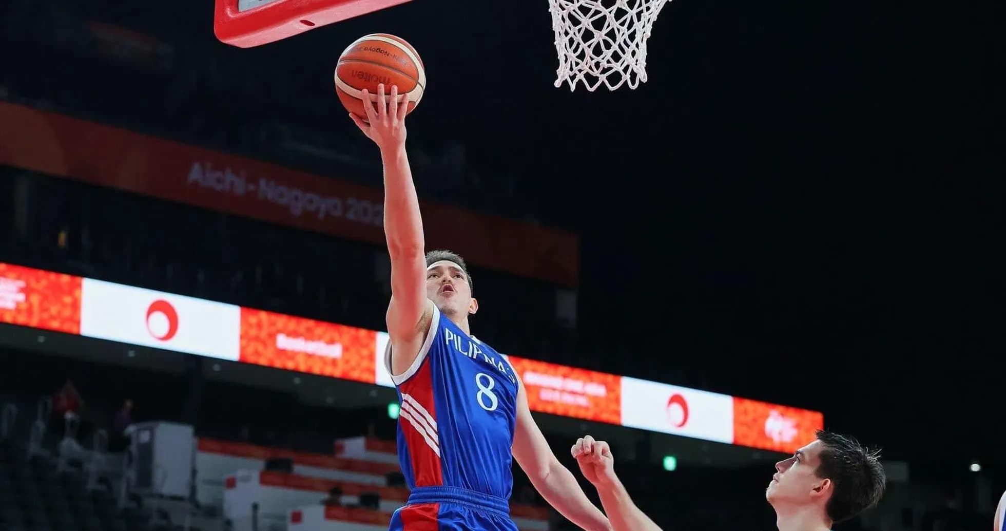 Jugador lanzando a canasta durante un partido de baloncesto