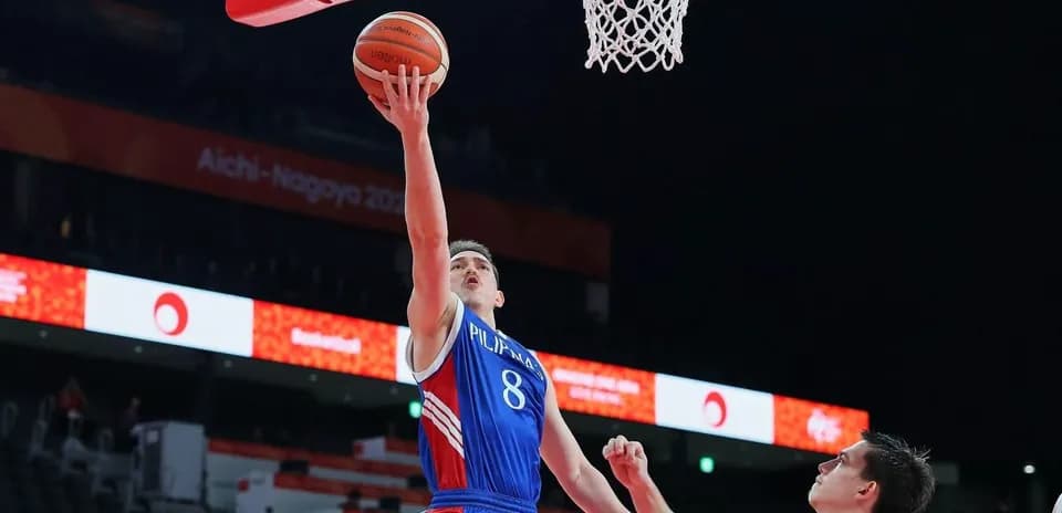 Jugador lanzando a canasta durante un partido de baloncesto