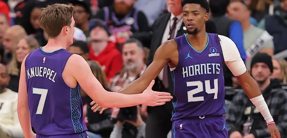 Jugadores de Hornets chocando manos durante el partido