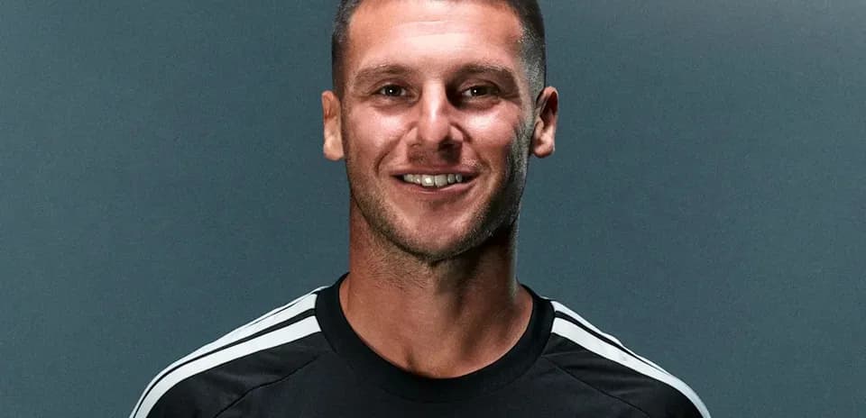 Jugador sonriendo en camiseta negra de equipo