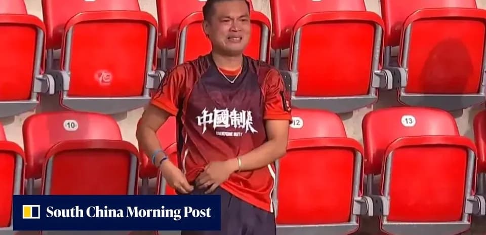 A fan in an orange jersey stands in empty stadium