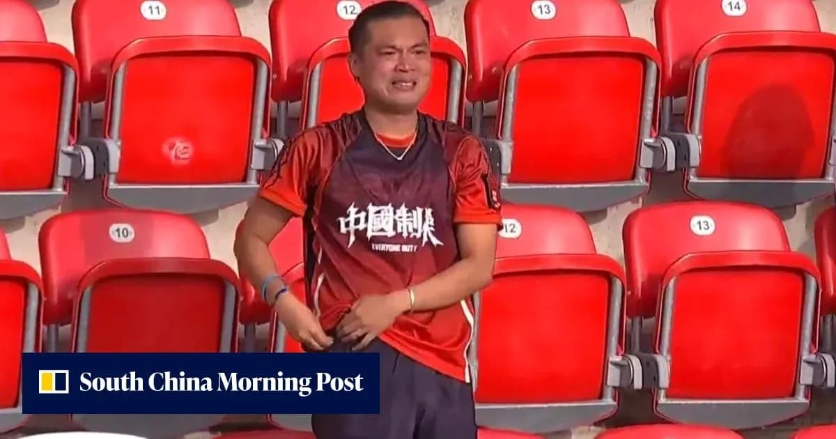 A fan in an orange jersey stands in empty stadium