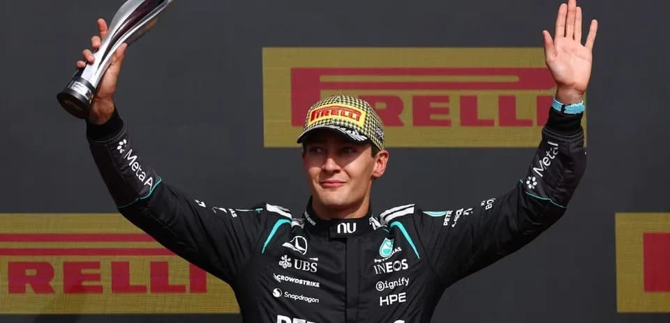 Piloto de Fórmula 1 levantando trofeo en podio