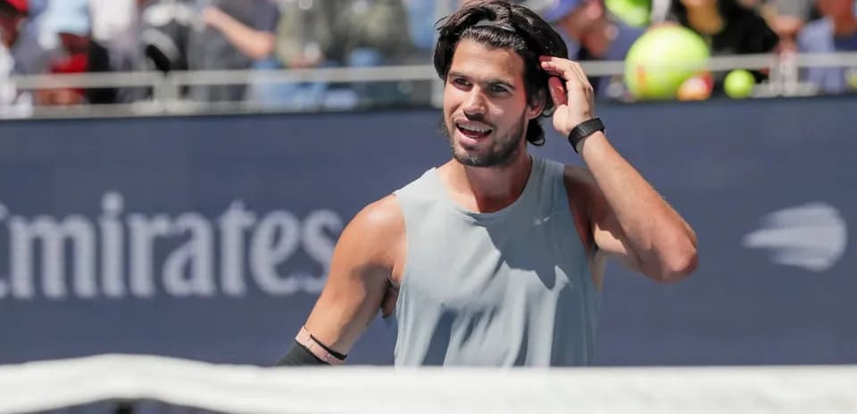 Jugador de tenis ajustando su cabello durante el partido