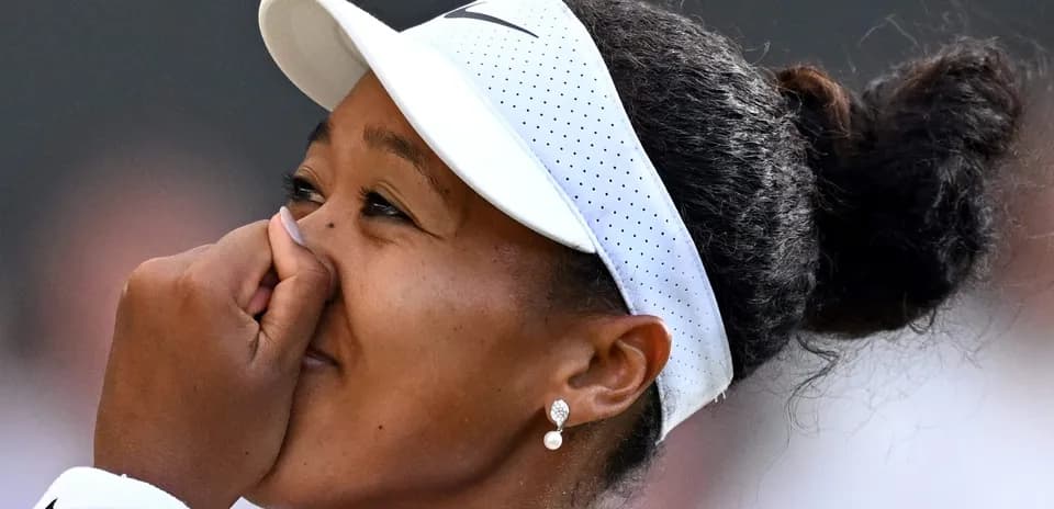 Naomi Osaka con gorra, tocándose la cara