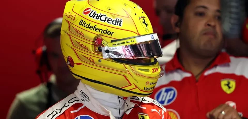 Piloto con casco amarillo en boxes de Ferrari