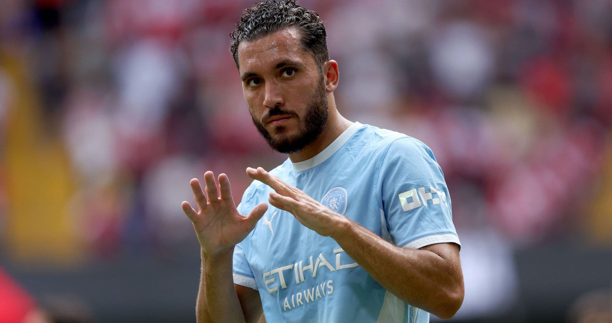 Jugador con camiseta de Manchester City saludando