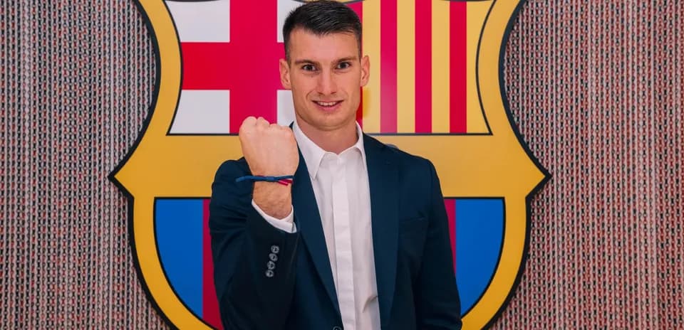 Jugador posando con el escudo del Barcelona de fondo