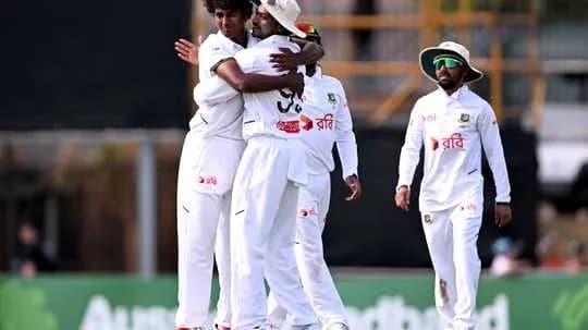 Jugadores de cricket celebrando una wicket en el campo