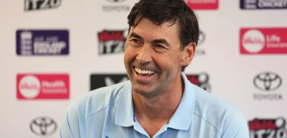 Entrenador sonriendo durante una rueda de prensa