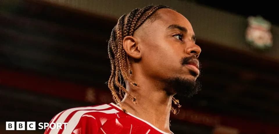 Jugador con trenza en camiseta roja en estadio