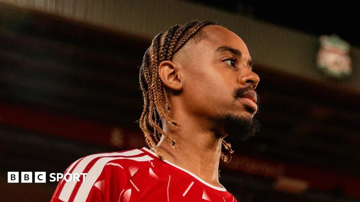 Jugador con trenza en camiseta roja en estadio
