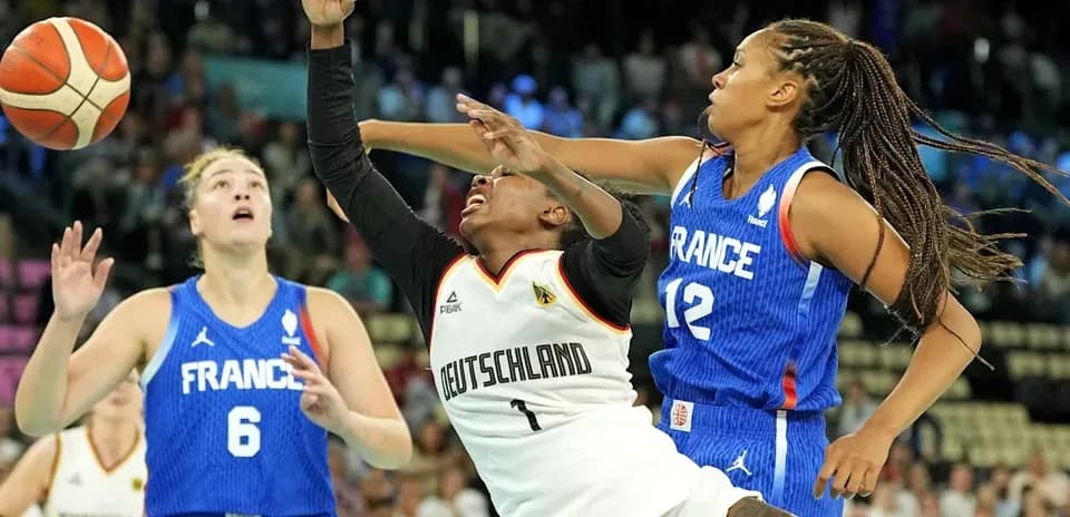 Jugadora de Alemania lanzando el balón ante defensa francesa