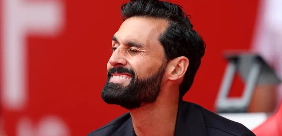 Hombre con barba sonriendo en un fondo rojo