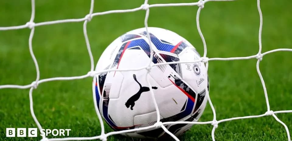 Balón de fútbol en la red de la portería