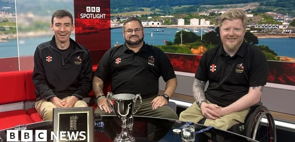 Tres hombres sentados con trofeo en estudio de televisión