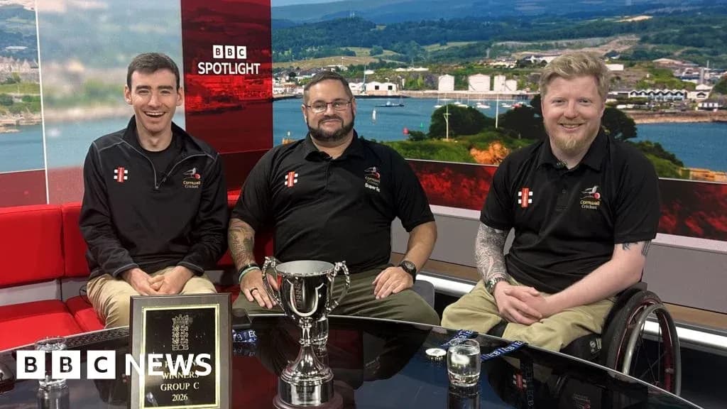 Tres hombres sentados con trofeo en estudio de televisión