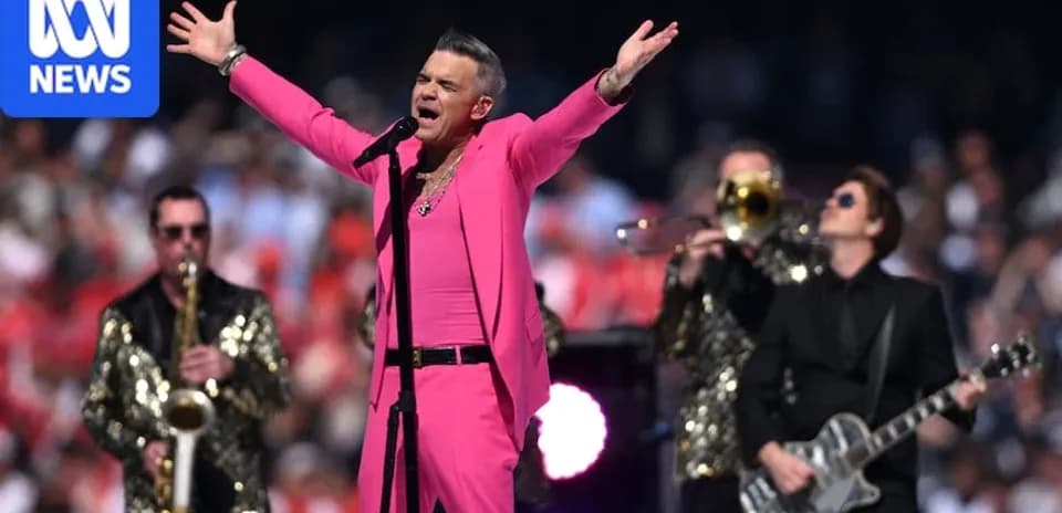 Robbie Williams actuando en un evento musical al aire libre