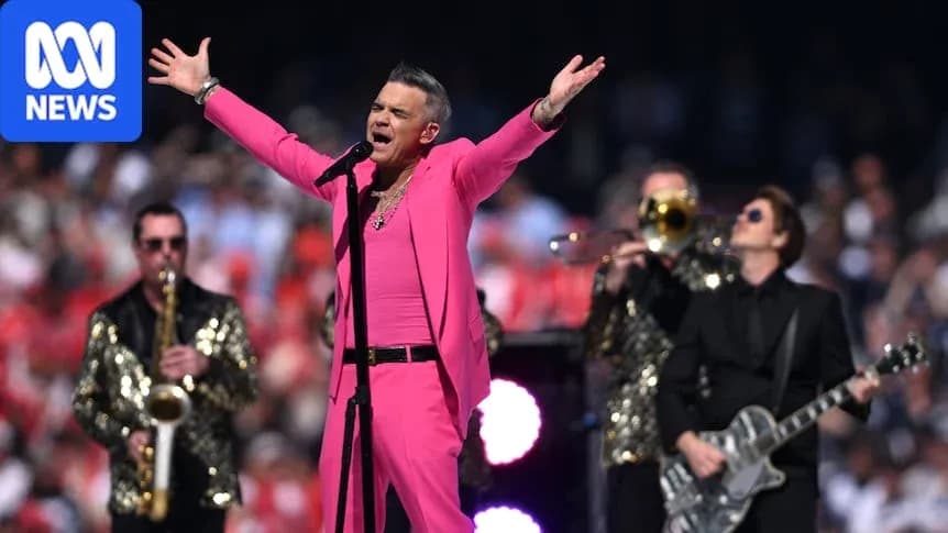 Robbie Williams actuando en un evento musical al aire libre