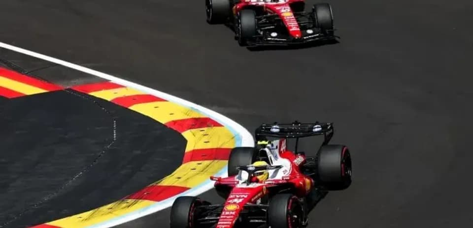 Dos coches de Ferrari tomando una curva en carrera