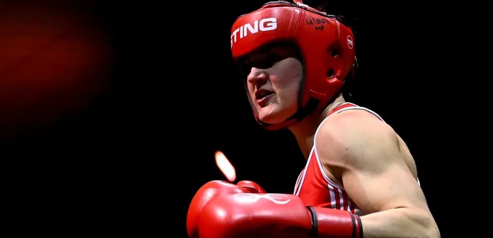 Boxeadora en acción con guantes rojos y casco