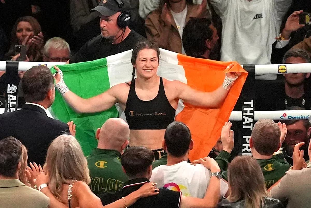 Boxeadora con bandera irlandesa celebrando en el ring