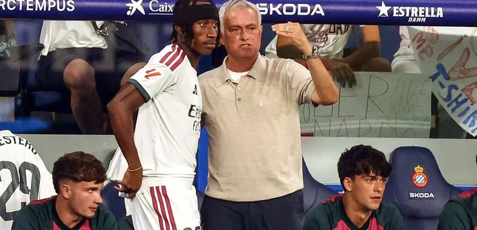 Entrenador hablando con jugador en la banca