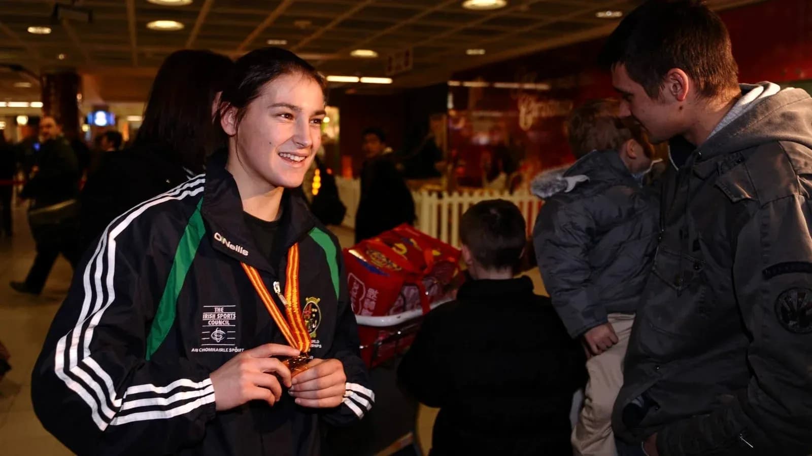 Atleta con medalla conversando en aeropuerto