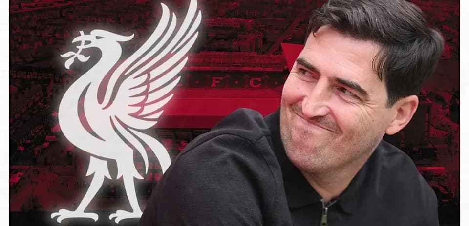 Entrenador sonriendo con logo de Liverpool de fondo
