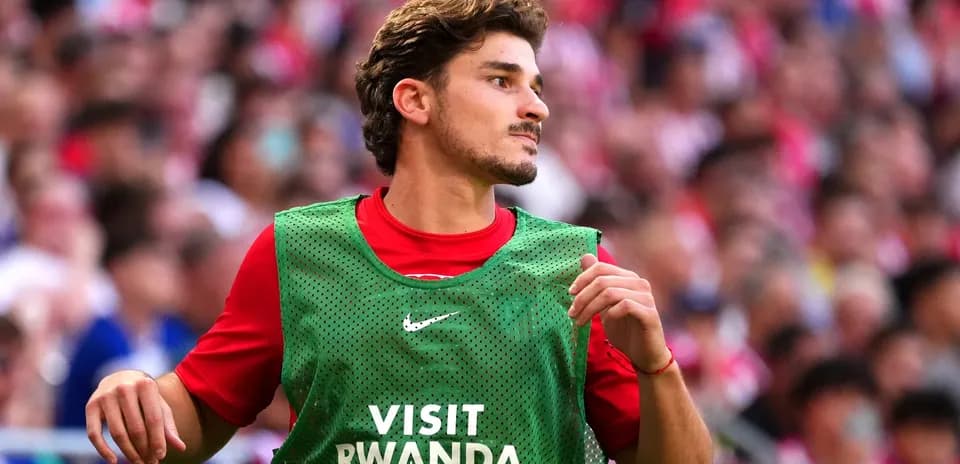 Jugador con pechera calentando en el banquillo