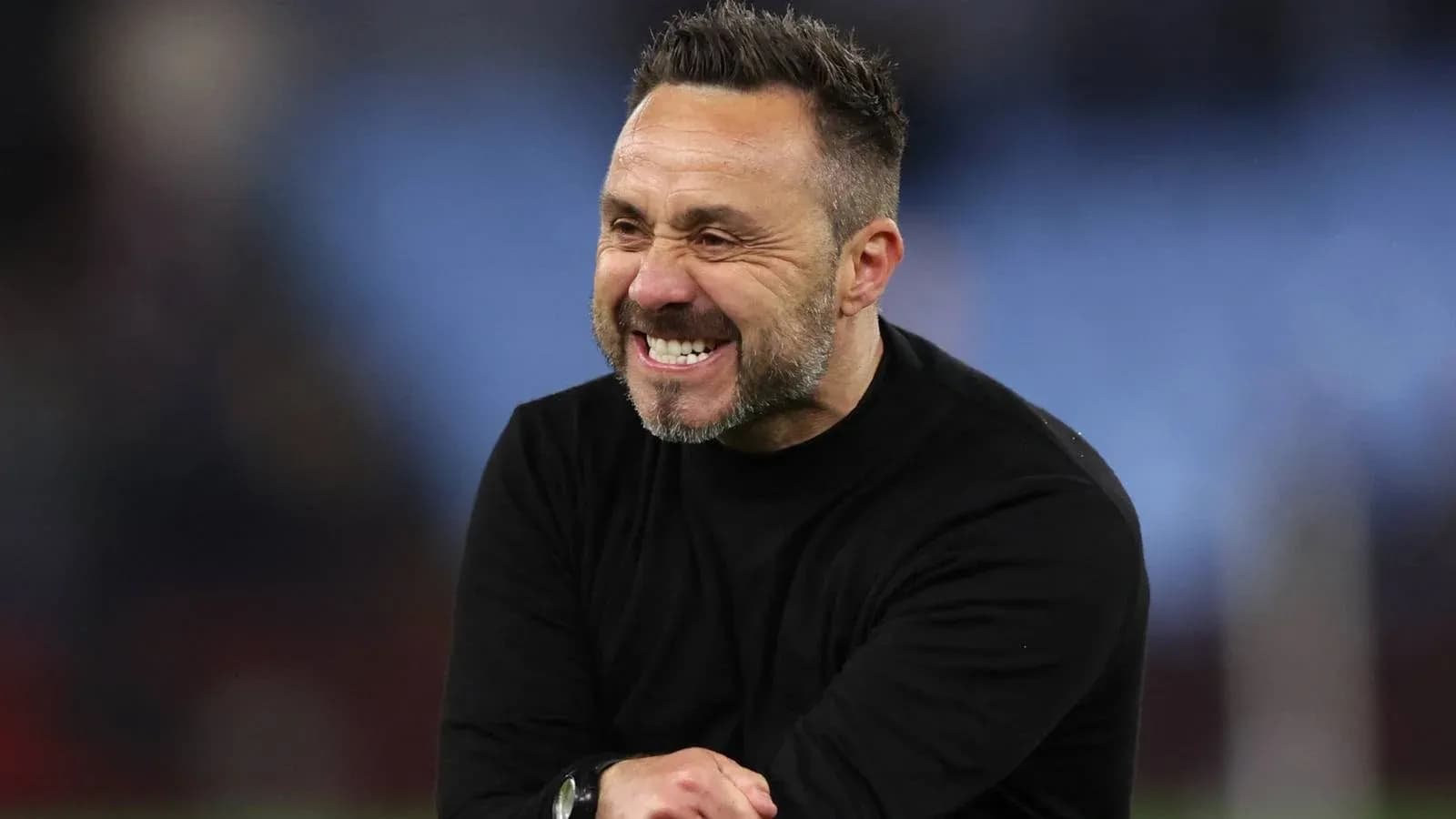 Entrenador sonriendo durante el partido