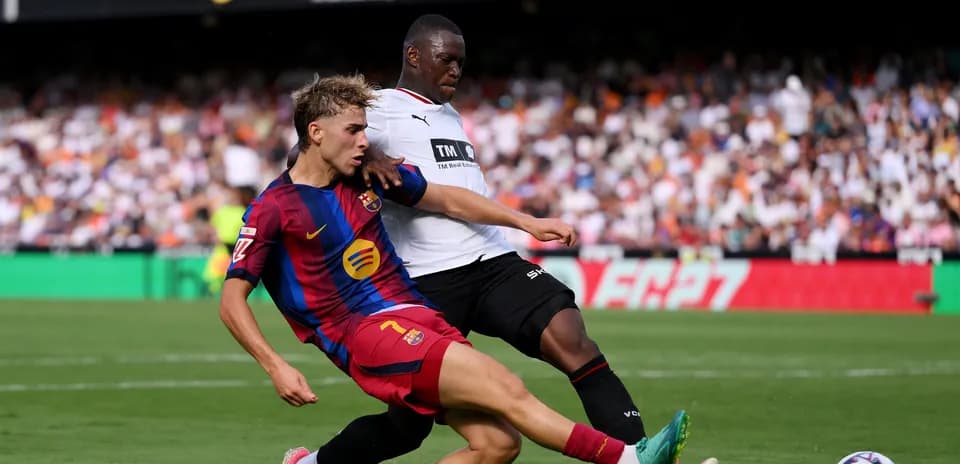Jugador de Barcelona y rival disputando el balón