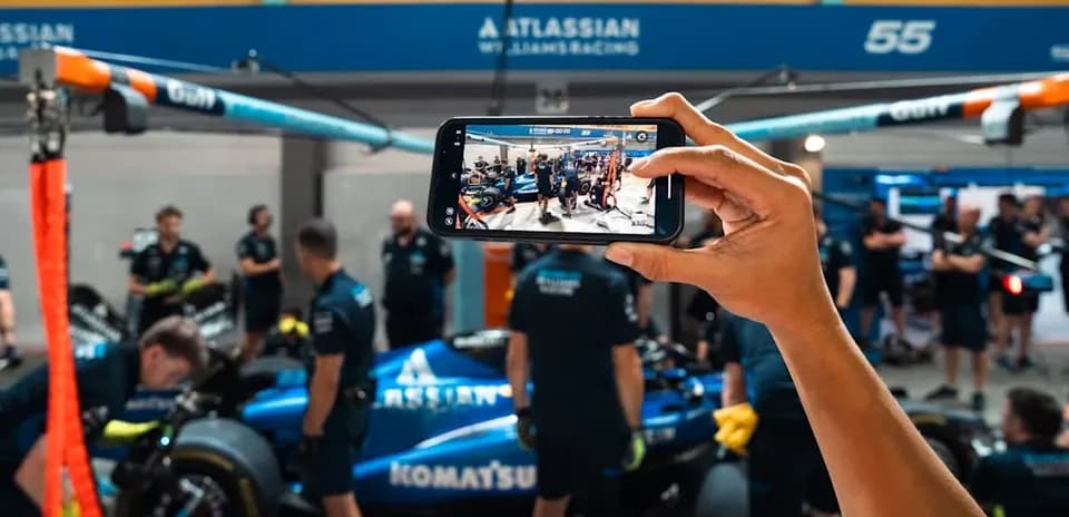 Persona tomando foto del equipo Williams en boxes