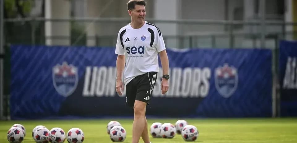 Entrenador caminando en campo de entrenamiento de fútbol