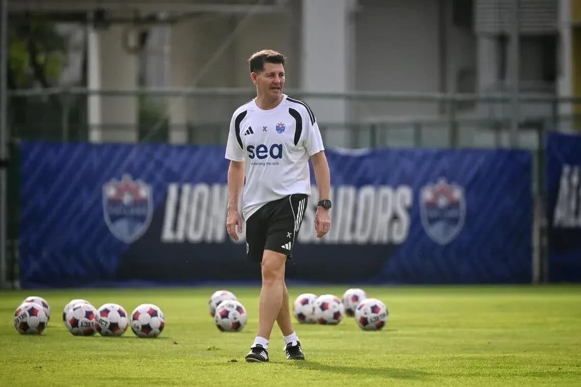 Entrenador caminando en campo de entrenamiento de fútbol