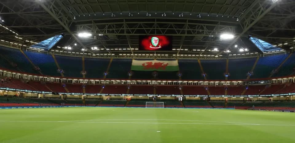 Estadio con césped y bandera de Gales visible
