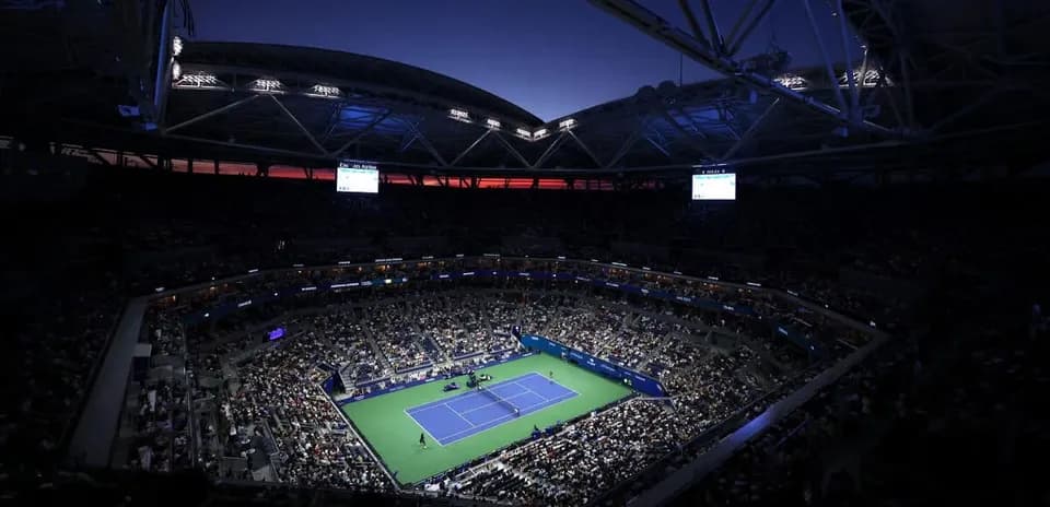 Estadio lleno durante un partido de tenis nocturno