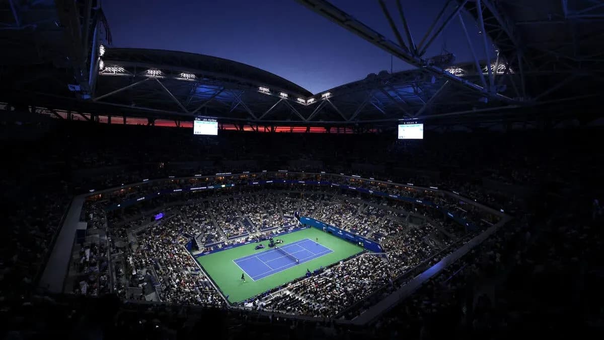 Estadio lleno durante un partido de tenis nocturno