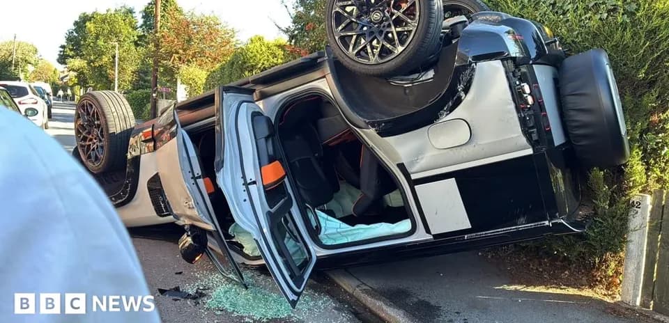 Coche volcado en la carretera con cristales rotos