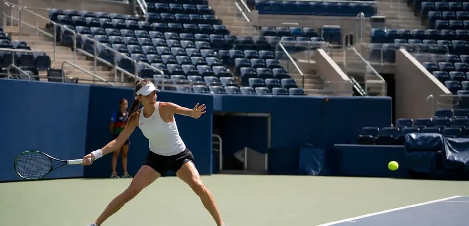 Jugadora de tenis golpeando una pelota en la cancha