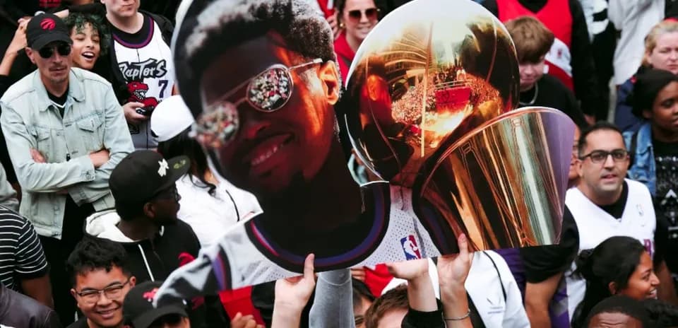 Fan holding a large cutout of a player and trophy