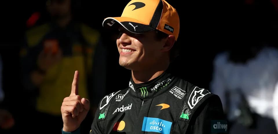 Piloto de McLaren mostrando el número uno con la mano