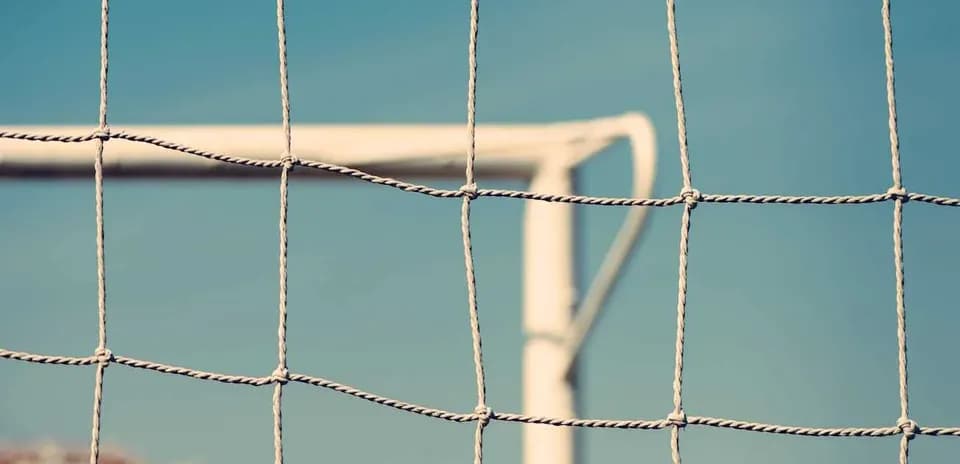 Red de una portería de fútbol contra un cielo azul